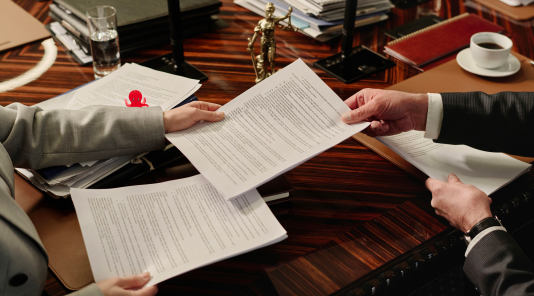 Une grande table avec deux personnes qui se partagent des documents